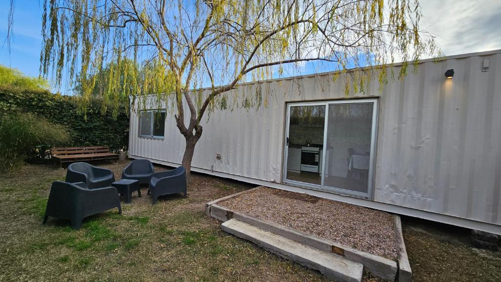 a small white trailer with two chairs and a tree at Container home in San Rafael