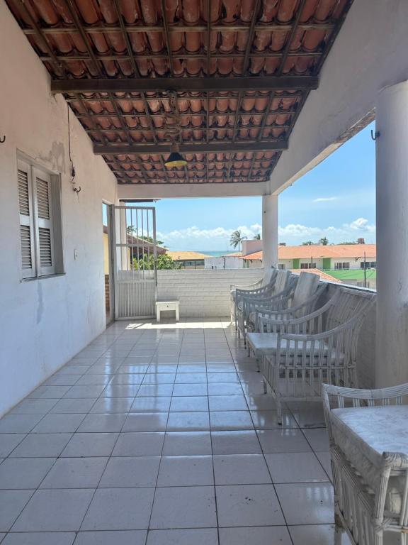 a porch with benches and tables and a view of the ocean at Casa Harmonia in Trairi