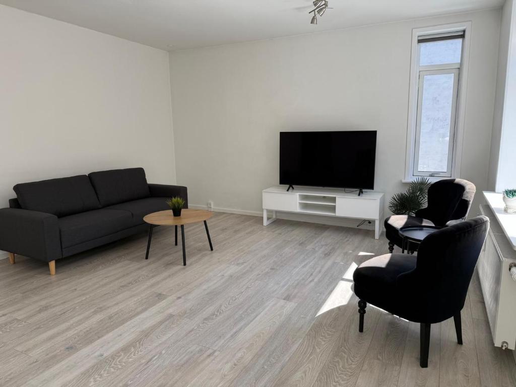 a living room with a couch and a flat screen tv at Lille Vedelsborg 1 in Vejle