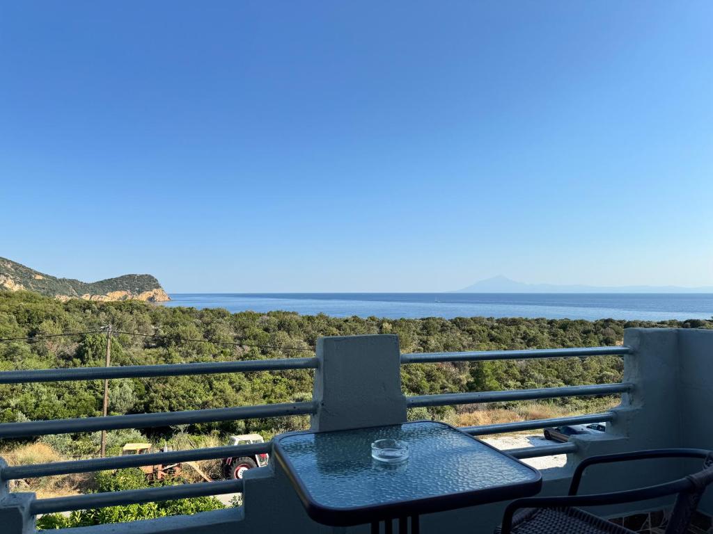 a table and chairs on a balcony overlooking the ocean at Siblings by the Sea in Skala Marion