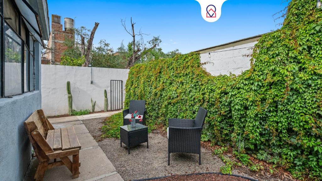 a patio with two chairs and a bench next to a wall at Your Home in León Top Location in León