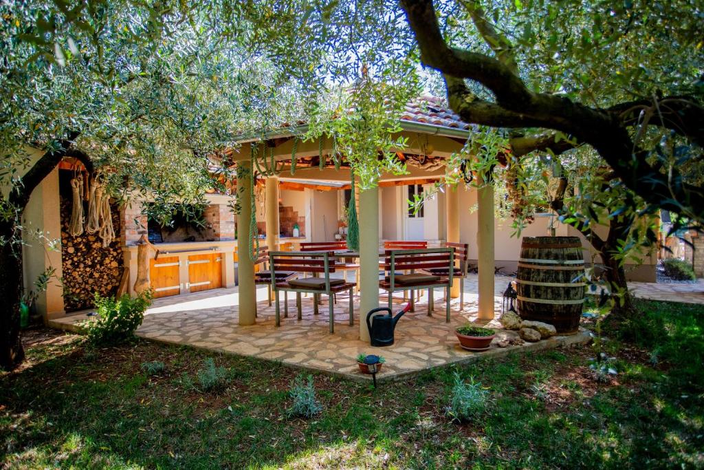 a patio with chairs and a table in front of a house at Casa Oliva Kim Marie /w Garden - Happy Rentals in Medulin