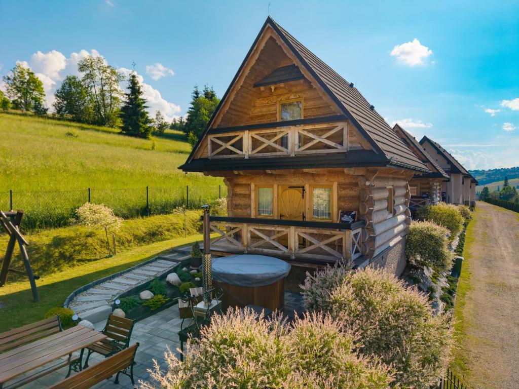 a log cabin with a bench in front of it at DOMKI NA WIERCHU in Biały Dunajec