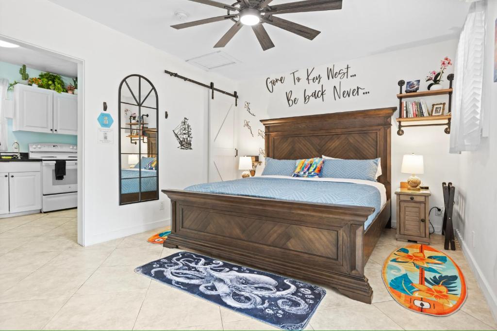 a bedroom with a wooden bed and a kitchen at Sailors Cabin - Prime Downtown Key West Spot - Walk to Duval in Key West