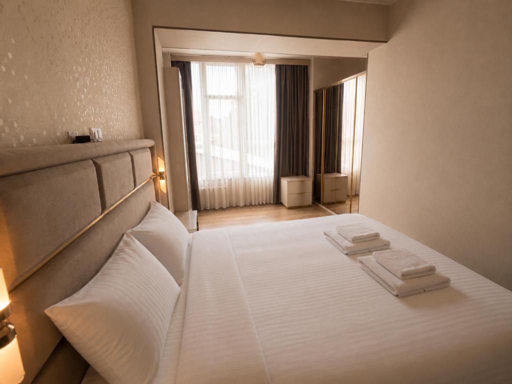 a bedroom with a white bed with two towels on it at Best apartment in Gonio