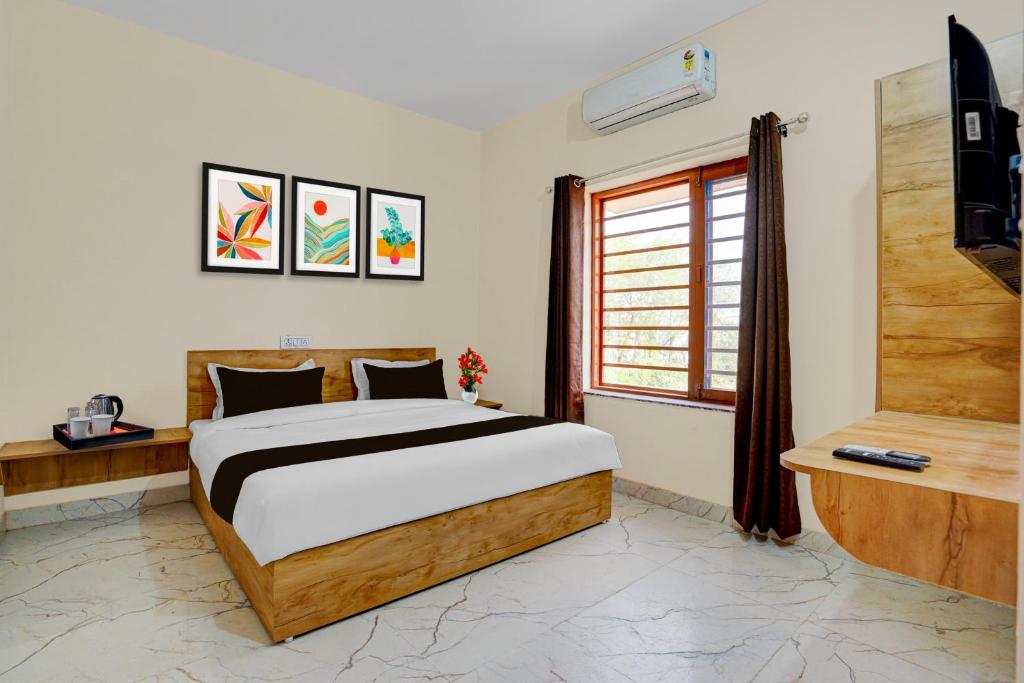 a bedroom with a bed and a television in it at Super Hotel O Dharampur Crossway in Mājra