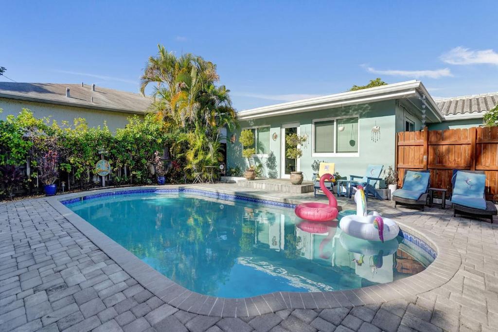 a swimming pool in a yard with a house at Caribbean Paradise Retreat Private Pool, Outdoor Kitchen & Jacuzzi in Fort Lauderdale