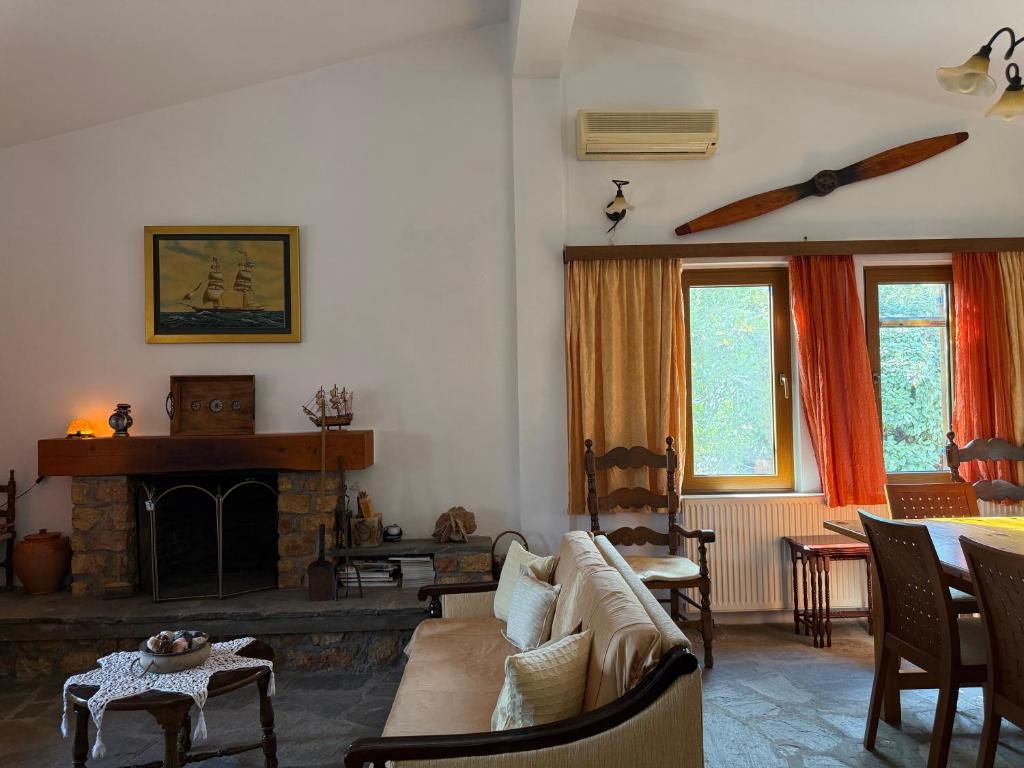 a living room with a couch and a fireplace at Casa Kaikos in Sevastí