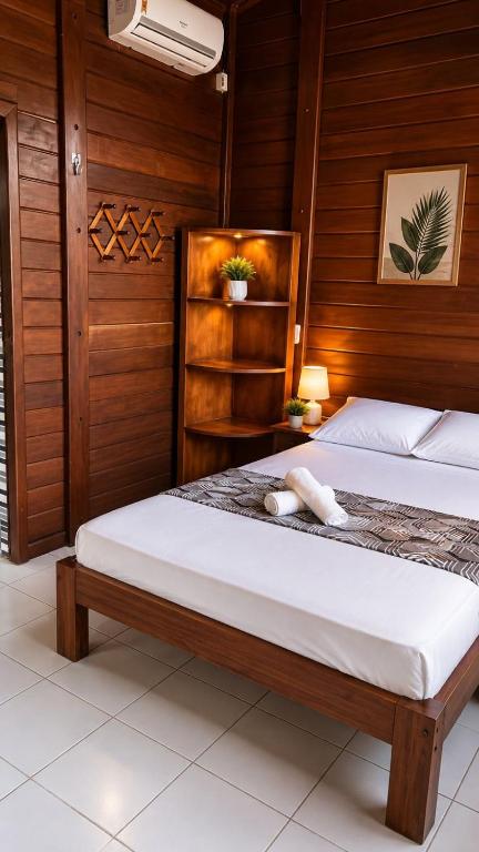 two beds in a room with wooden walls at Pousada Jangá Jeri in Jericoacoara