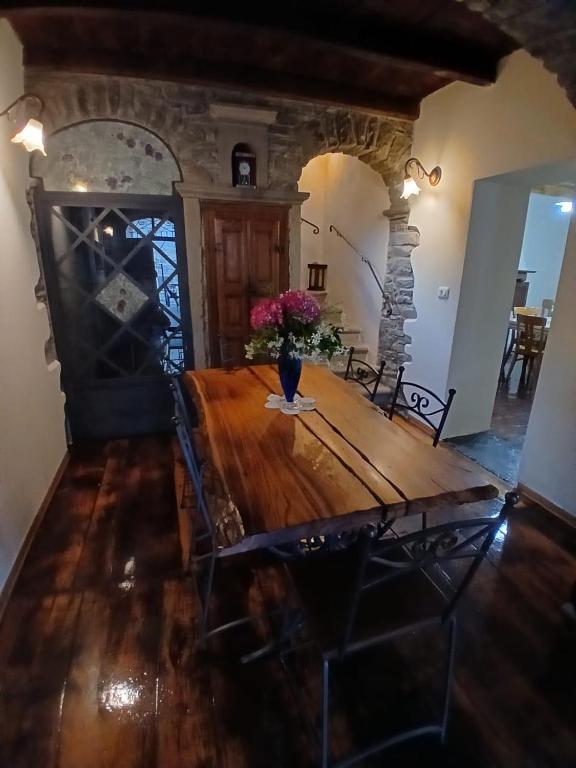 a dining room with a wooden table with flowers on it at Eva house 1 in Fanano