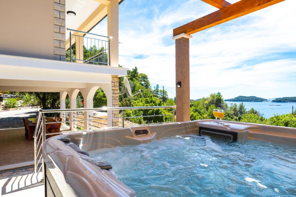 a hot tub on the balcony of a house at Villa Franciska in Blato