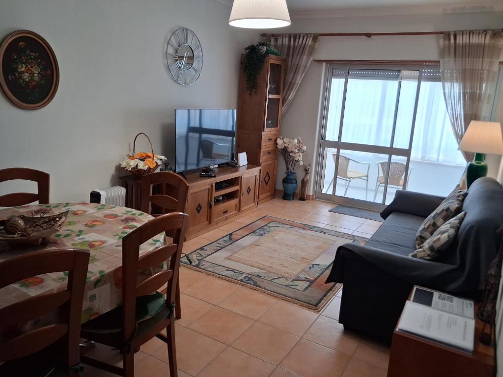 a living room with a couch and a tv and a table at Apartamento Milo in Loures