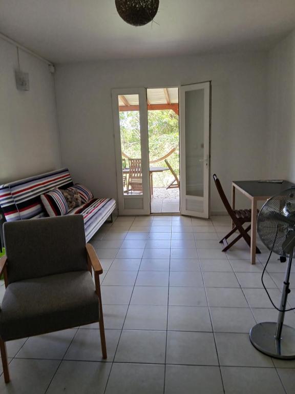 a living room with a chair and a table at Jolie maison avec terrasse in Partarieux