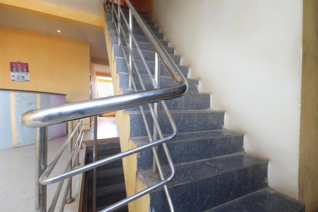 a staircase in a building with a metal railing at Hotel O by OYO Kb Residency in Kurinjippādi