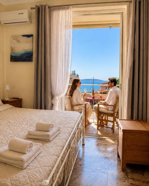 a man and woman sitting in a room with a bed at Farniente Tolo in Tolo