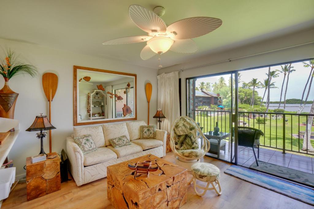 a living room with a couch and a large window at Beachside Molokai Condo w/ Lanai & Pool Access! in Kaunakakai