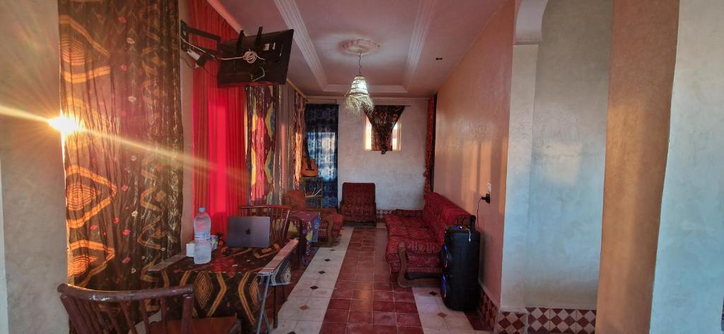 a dining room with tables and chairs and a red wall at appart villa galactik pegasus in Aourir