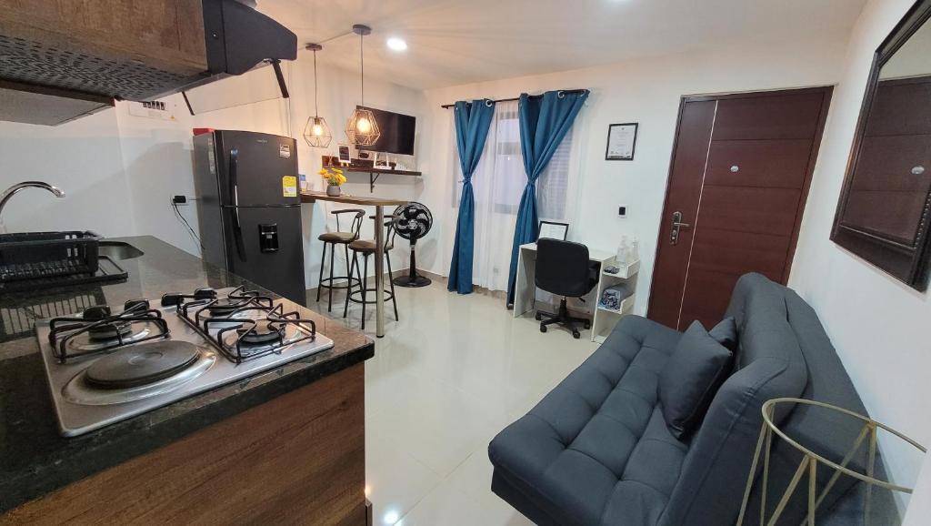 a kitchen and living room with a stove and a couch at Estudio cerca a puerta del norte in Bello