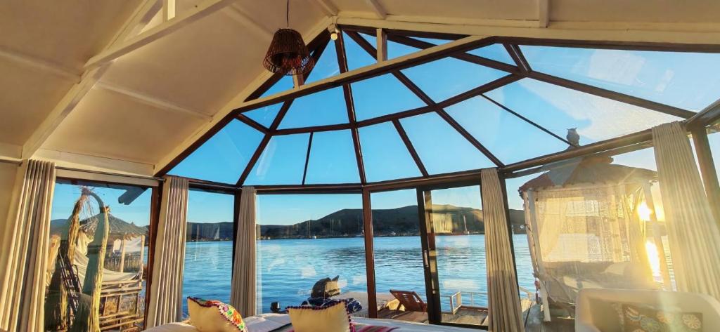 a room with a large window with a view of the water at Titicaca wasy lodge in Puno