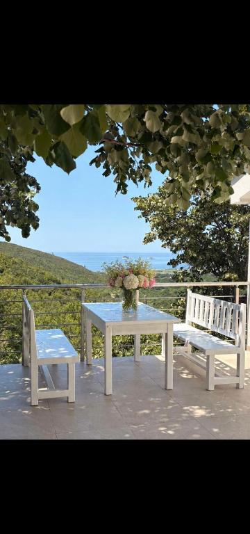 a table and two chairs on a patio with a vase of flowers at Sea&Forest view in Buljarica