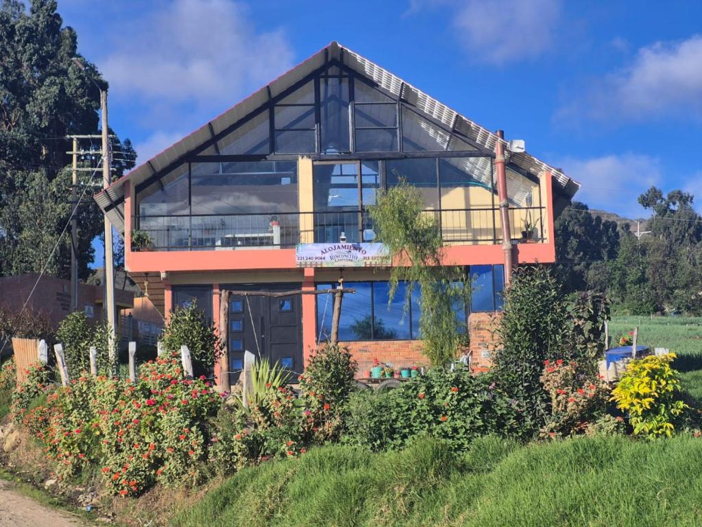a house with large glass windows on a hill at Rinconcito campesino in Aquitania