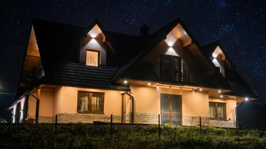 a house lit up at night under a starry sky at Małe Ciche 36j PRZY OSTREWKACH, Widok na góry, Blisko do wyciągu narciarskiego, Idealne miejsce na wypad w góry -tarasówka-zgorzelisko-rusinowa polana-gesia szyja-palenica-wiktorówki-morskie oko in Murzasichle