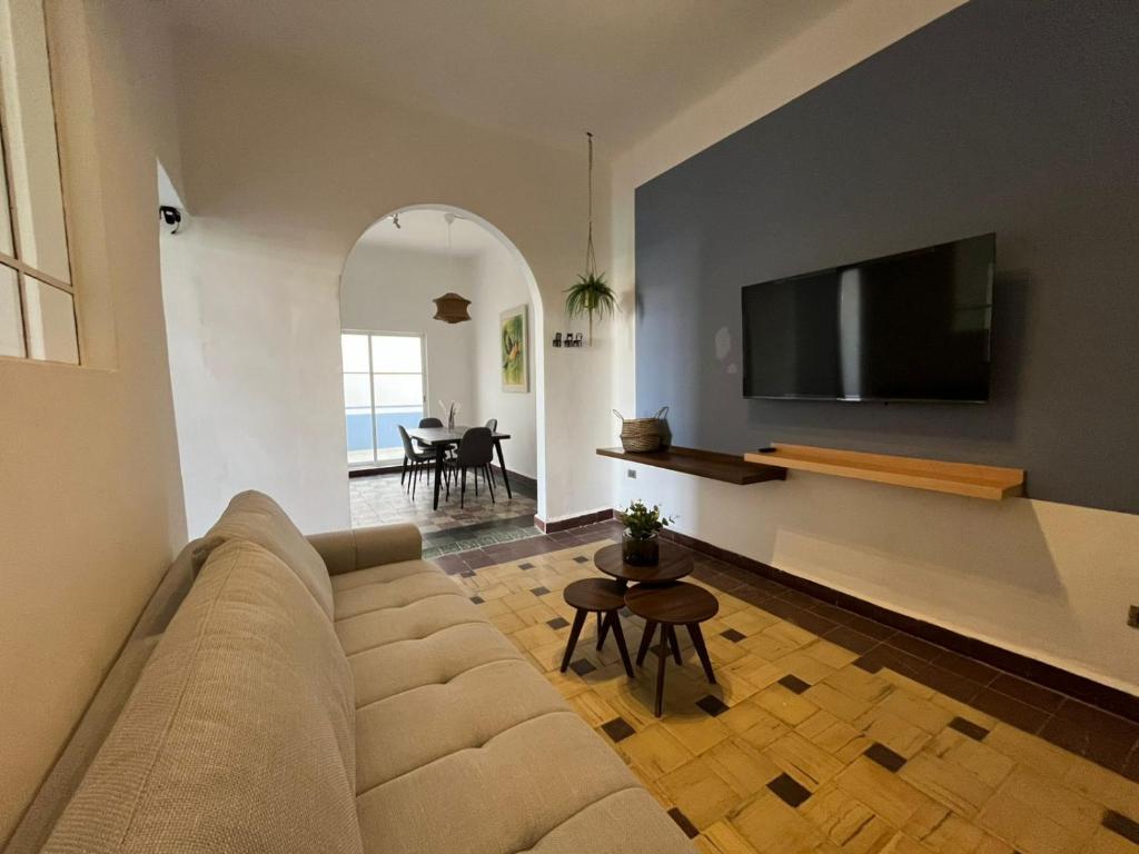 a living room with a couch and a flat screen tv at Departamento 101 Casona Catalina in Puebla