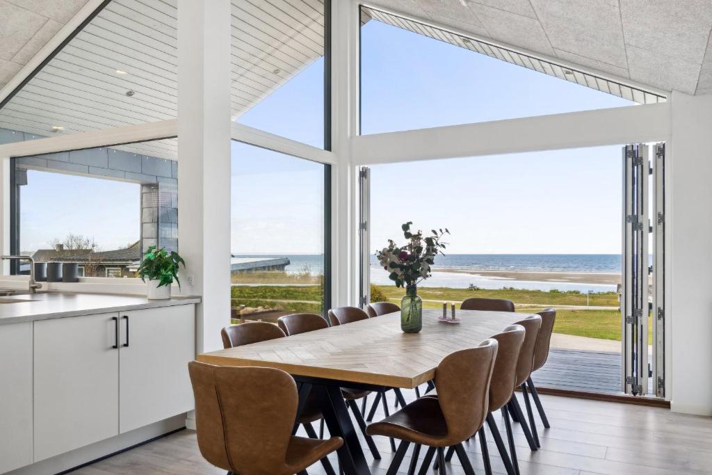 a kitchen and dining room with a table and chairs at Seaside Cottage With A Stunning View in Allingåbro