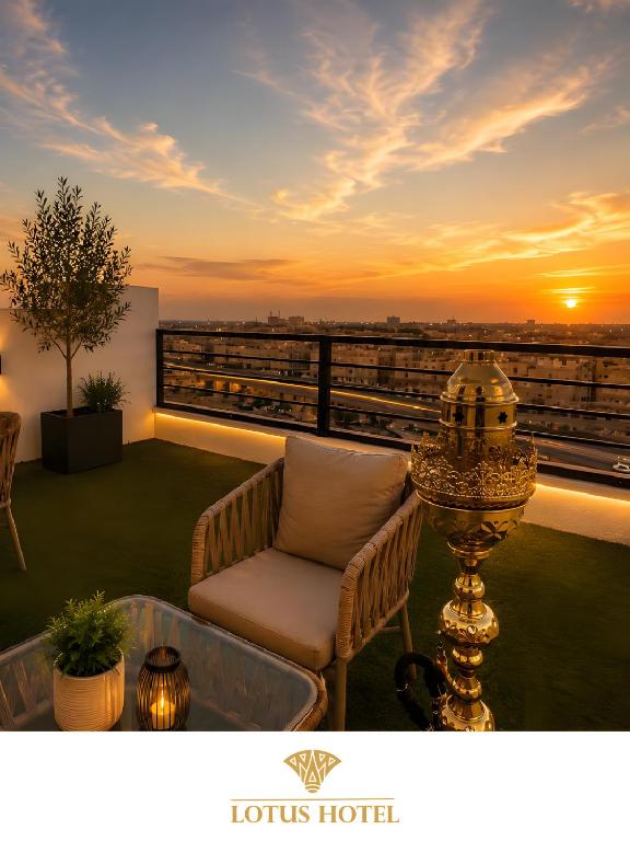 a balcony with a chair and a sunset at Lotus Apartments l New Cairo in Cairo