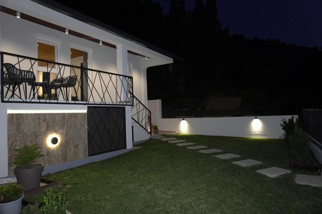 a house with a balcony at night at Blue Yard in Lepetani