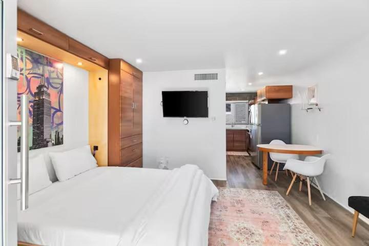 a bedroom with a bed and a table and a kitchen at DTPH Cozy Corner - Pool & Parking in Phoenix
