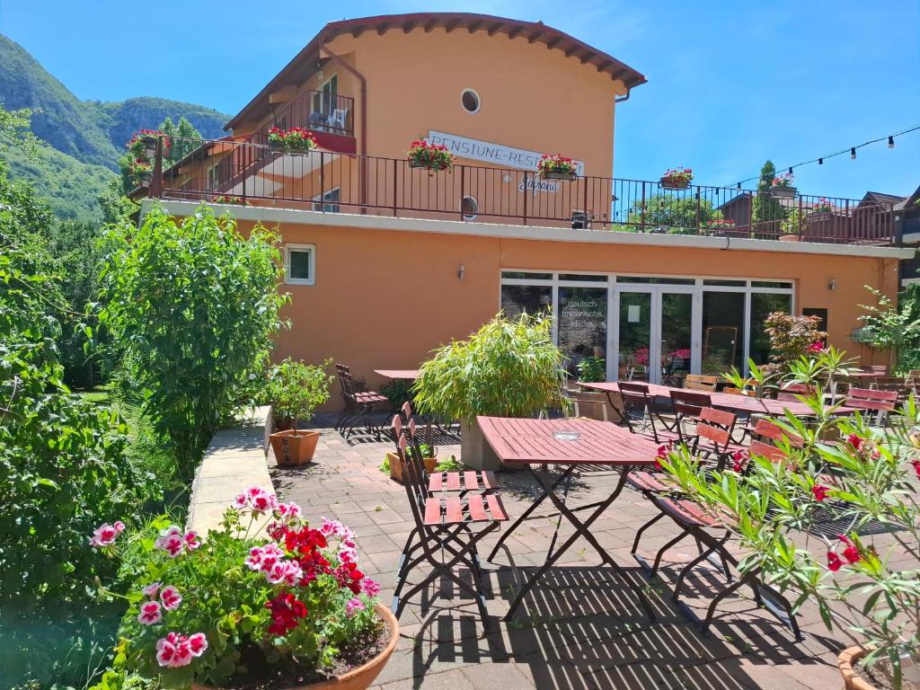 a patio with tables and chairs in front of a building at Pensiune Safrane in Băile Herculane