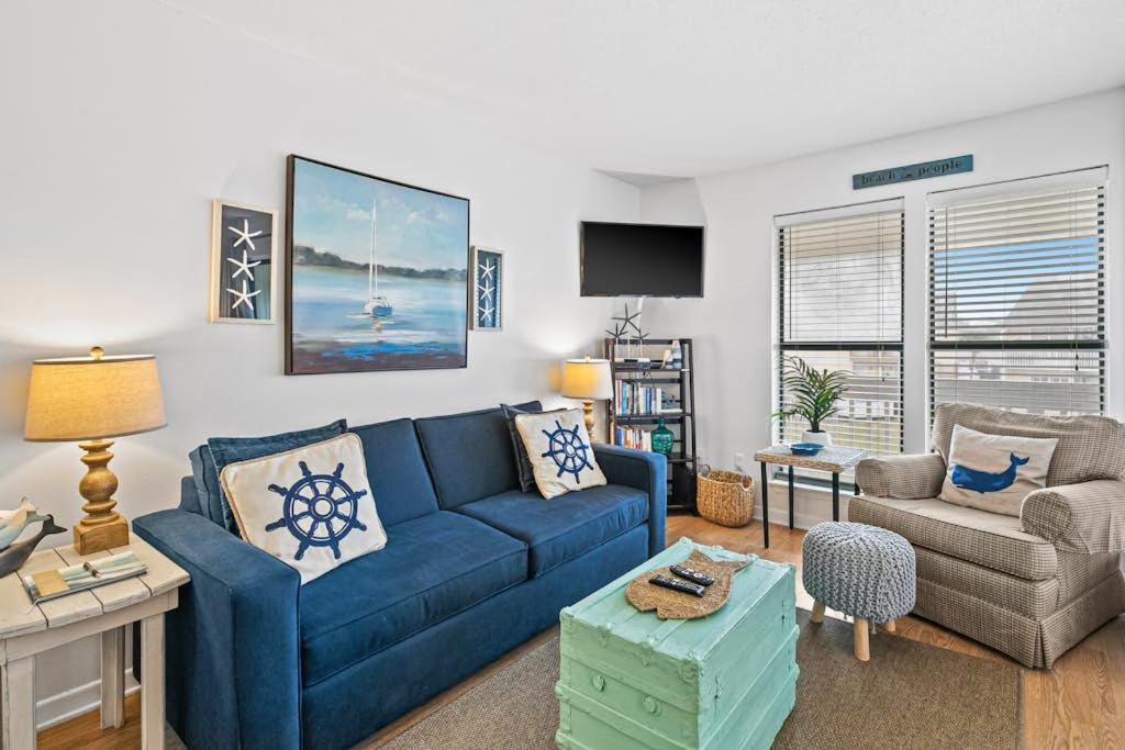 a living room with a blue couch and a chair at Coastal Condo with heated pool hot tub tennis & beach access in Destin
