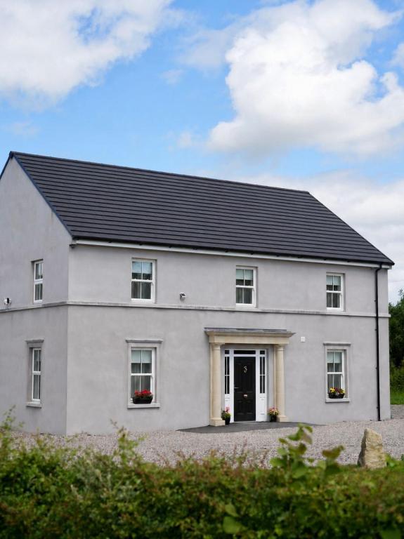 a white house with a black roof at Carland Cottage in Carland