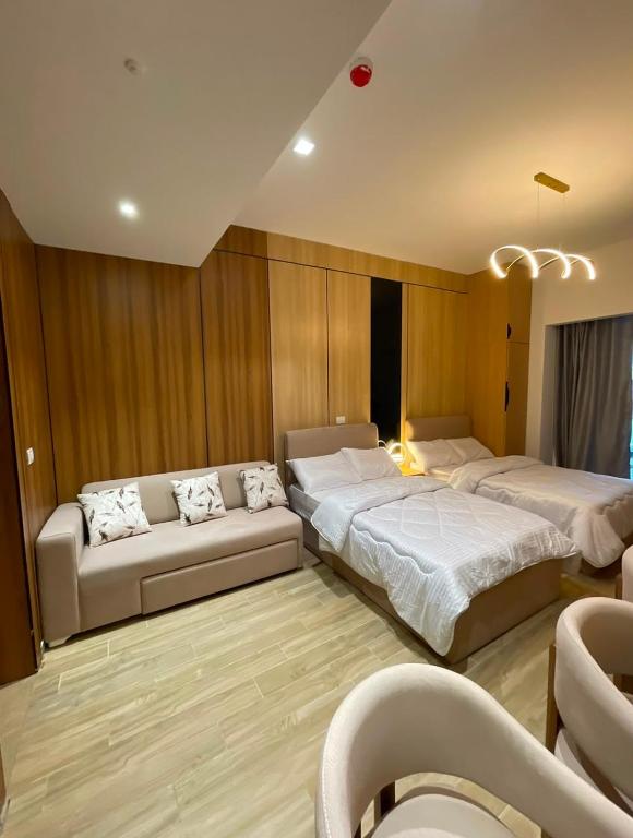 a bedroom with two beds and a couch at The Gate 05 New Alamein in El Alamein
