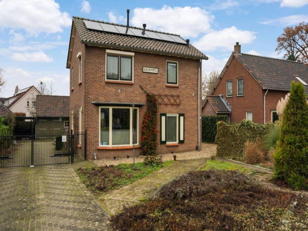 ein Backsteinhaus mit einem Zaun davor in der Unterkunft Hoevendeel in Eefde