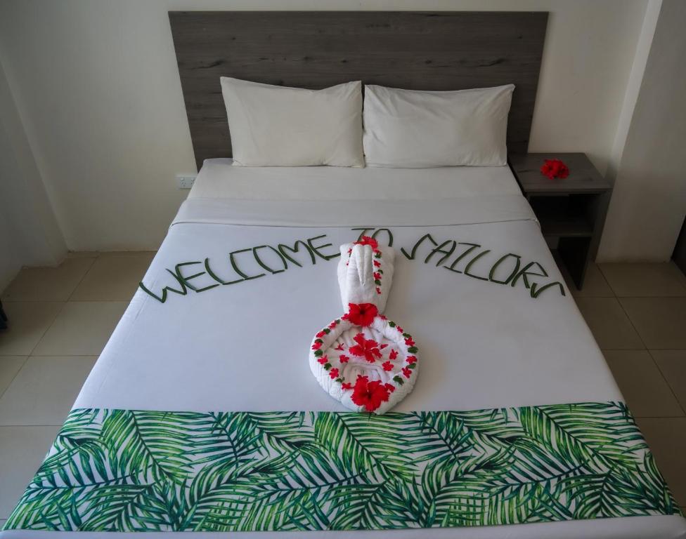 a white bed with a welcome pillow on it at Sailors Beach Fiji in Nadi