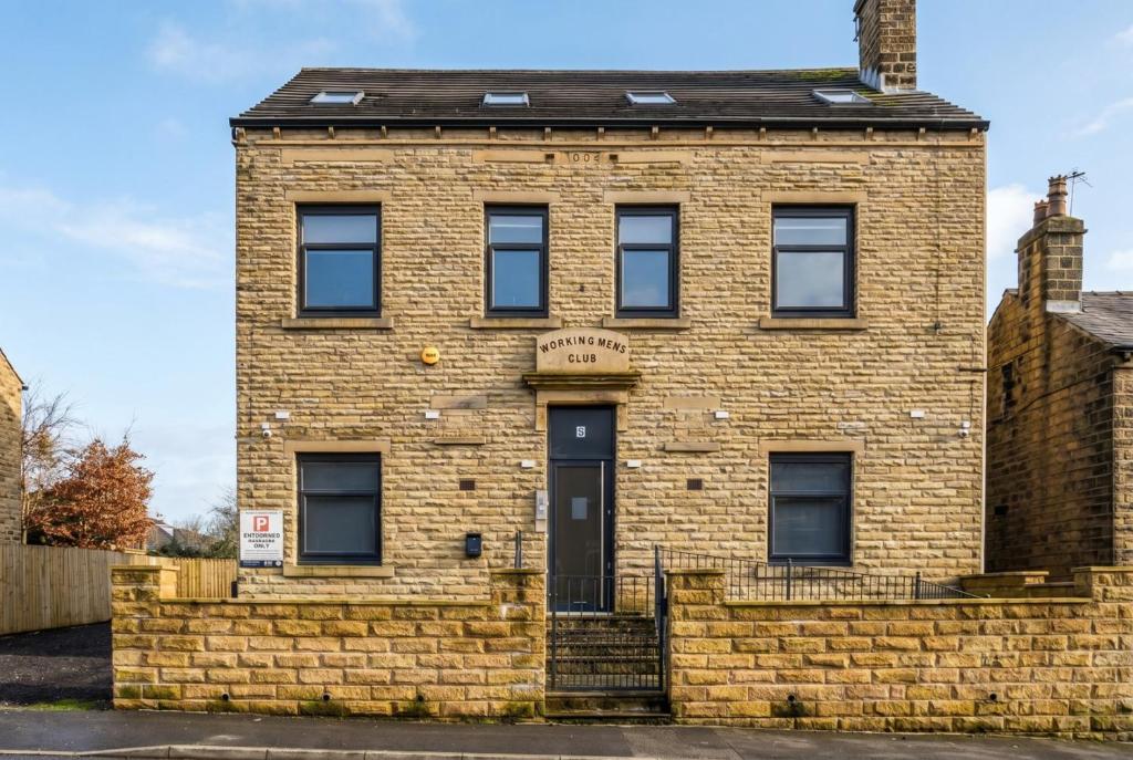 an old brick building with a brick wall at St John's Flats, Newsome in Huddersfield