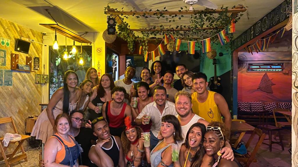 a group of people posing for a picture in a room at Chamos Hostel Cultural in Arraial do Cabo