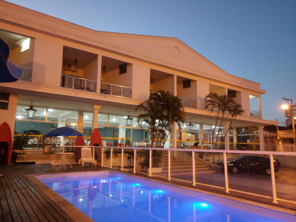 a hotel with a swimming pool in front of a building at Iter Hotel in Rifaina