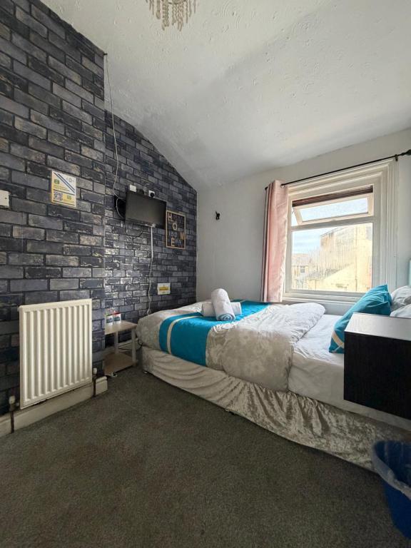 a bedroom with two beds and a brick wall at Suncrest Hotel # Self-check-in in Blackpool