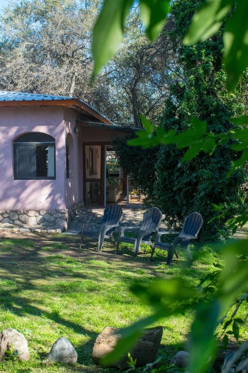 a group of chairs sitting in a yard at Casa Armonía in Villa Las Rosas
