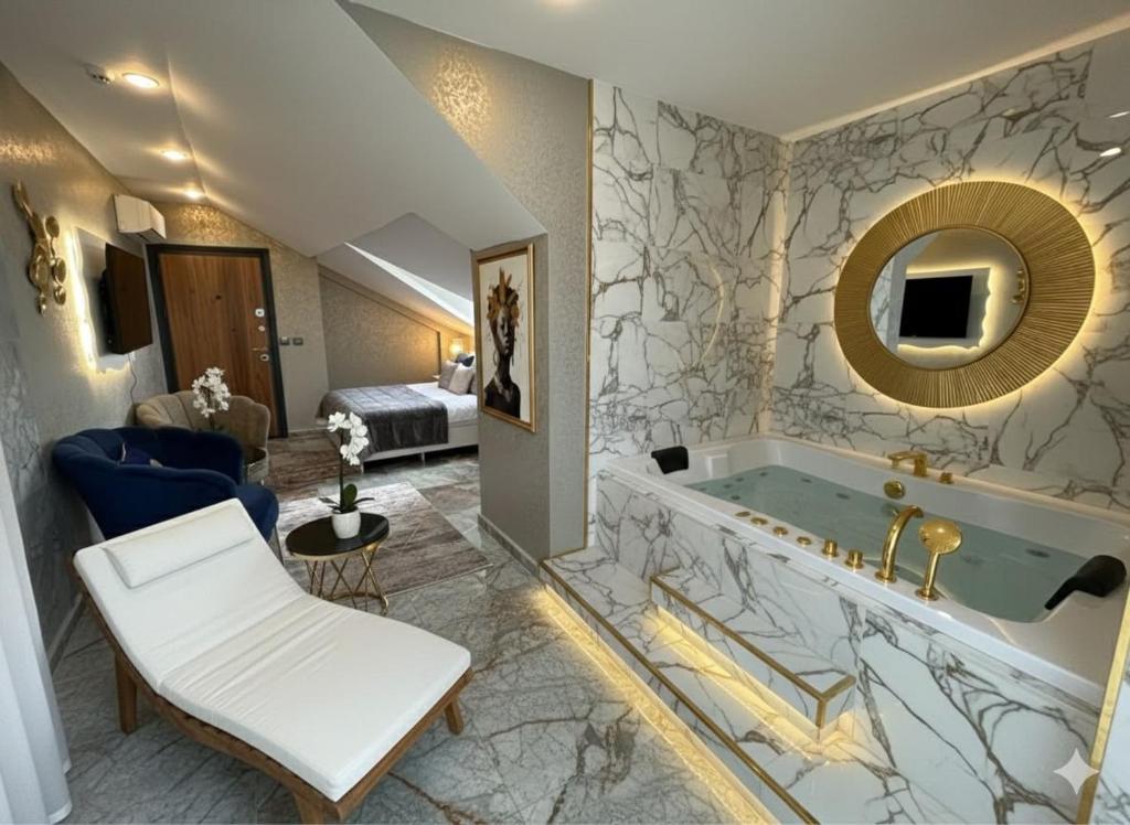 a hotel room with a tub and a bedroom at Viyana Suite Hotel in Istanbul