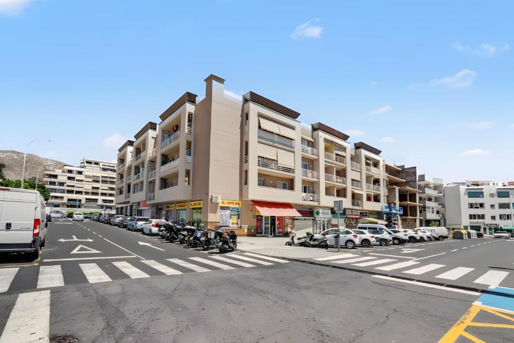 a large building with cars parked in a parking lot at Los Cristianos plaza property in Los Cristianos