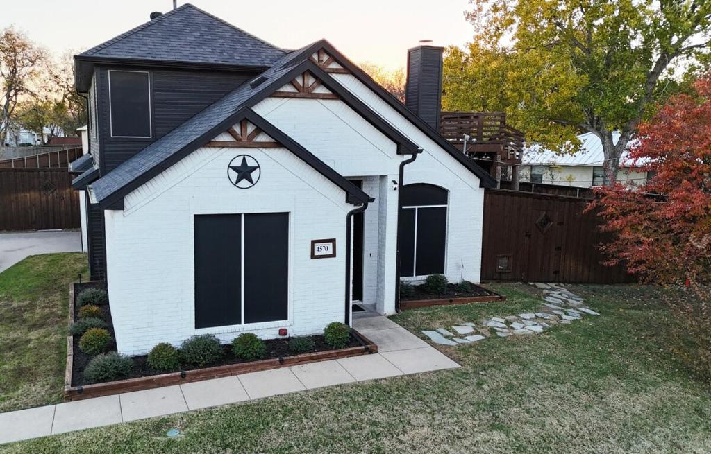 a white house with a black roof at North Shore Lake Community in The Colony