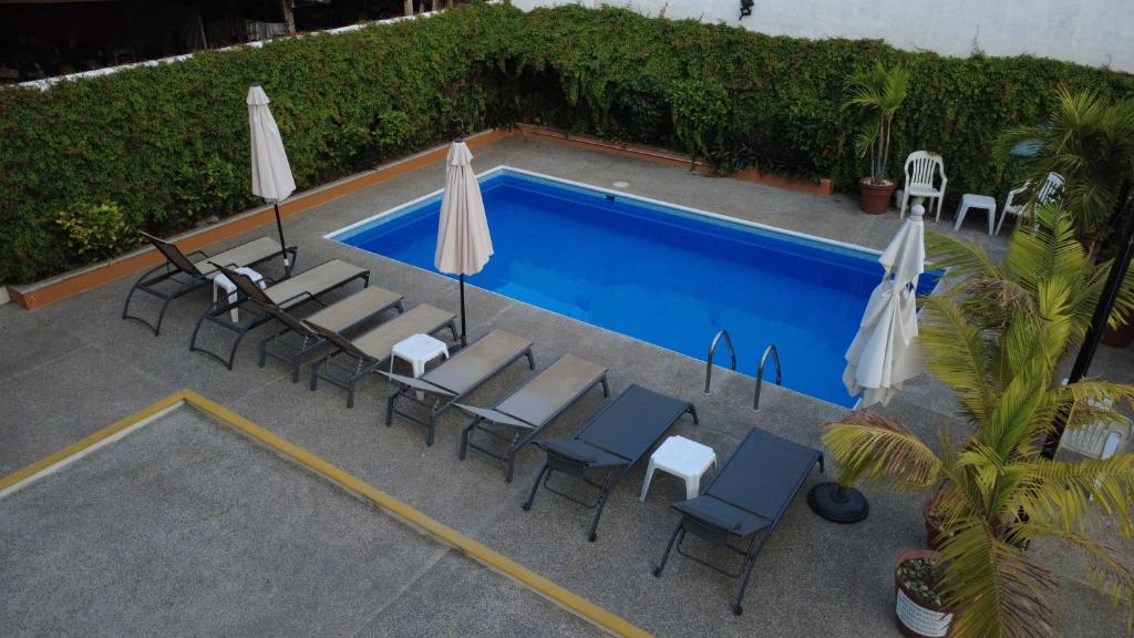 an overhead view of a swimming pool with chairs and umbrellas at DEPARTAMENTOS LALO in Zihuatanejo