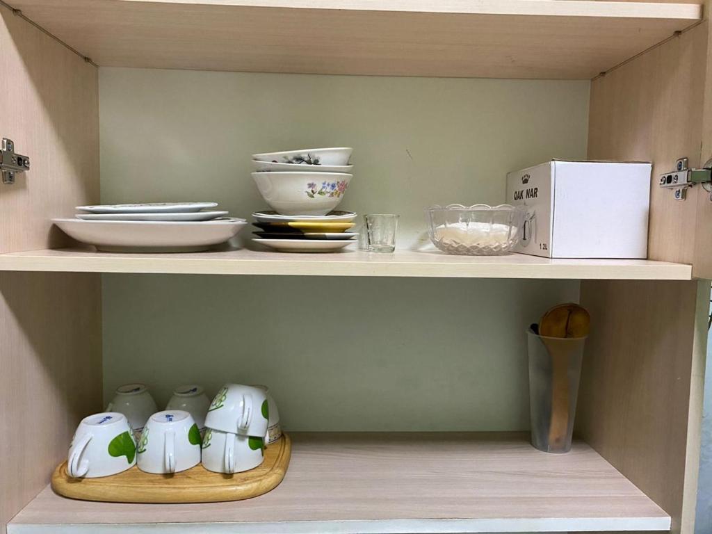 a shelf with bowls and dishes on it at Грин сити in Balykchy