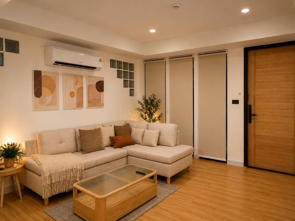 a living room with a couch and a coffee table at Punnawithi House Bangkok in Amphoe Phra Khanong