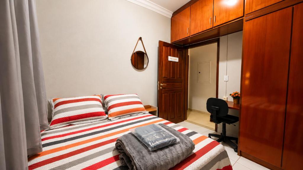 a bedroom with a bed and a desk in it at Pousada Bem Estar Frutal in Frutal