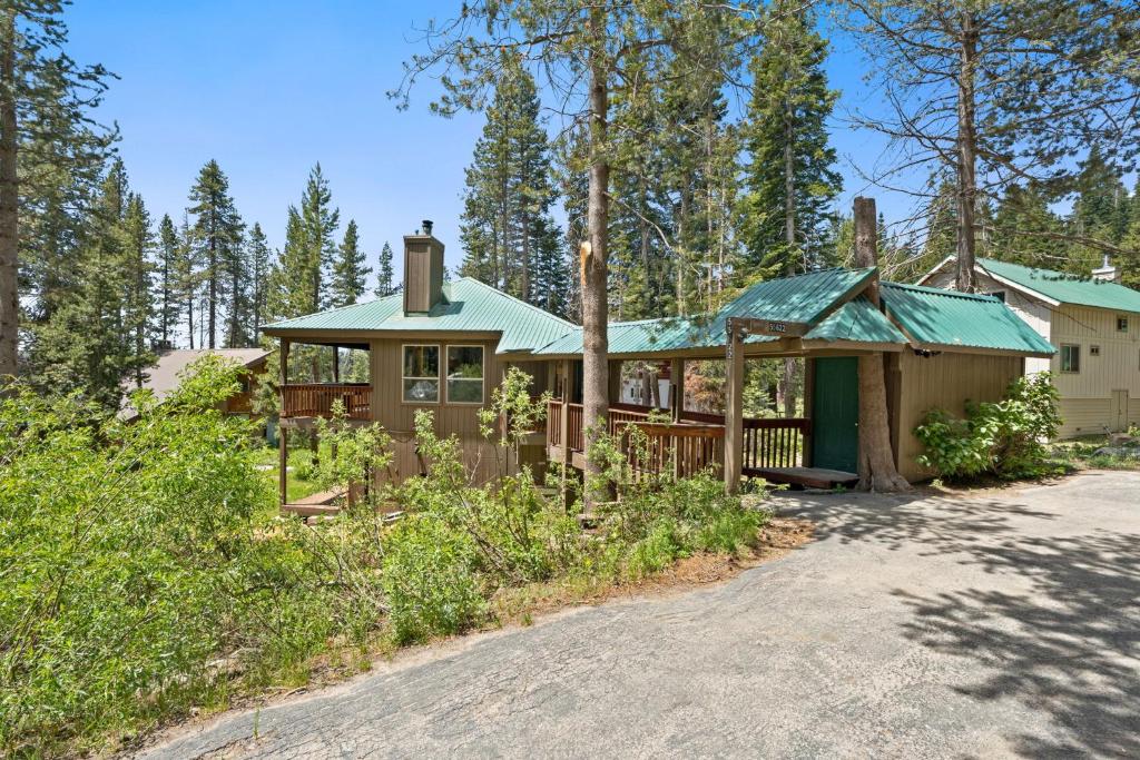 a house with a green roof in the woods at Stargazing Retreat in Tamarack in Big Creek